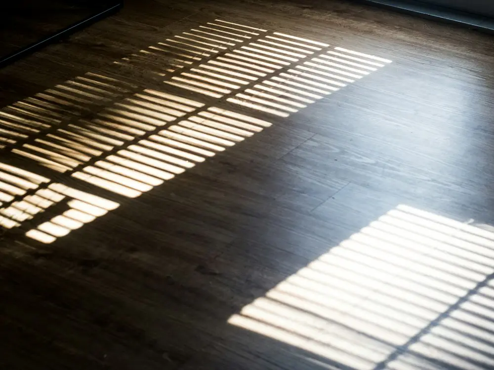 Donkere PVC vloer met warm zonlicht op vloerverwarming